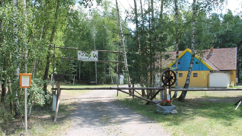 SOLA Langau, © Hannes Messmann Entrance to a storage area with a yellow building in the background.