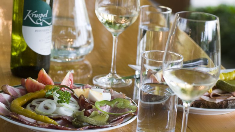 A laid table with a Heurigen snack, wine and water.