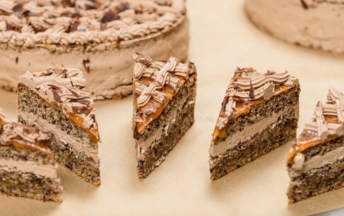 Close-up of sliced chocolate cake pieces with cream and chocolate icing.
