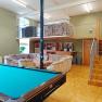 A youth room with a pool table, sofas and a gallery with stairs.