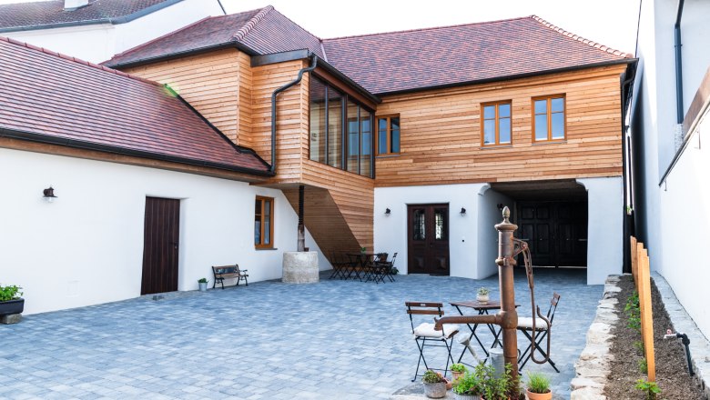 Guesthouse Teufelsbauer, © Melanie Rutschek Inner courtyard of a guest house with wooden elements and paved floor.