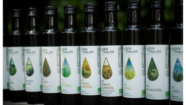 Row of Hagenthaler oil bottles on a wooden table.