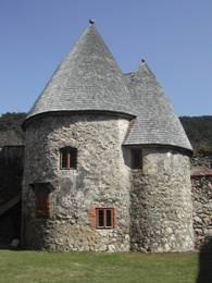 Stone tower with two conical roofs and small windows.