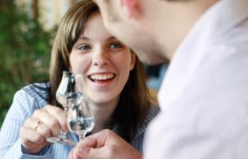 Two people clink glasses and smile.
