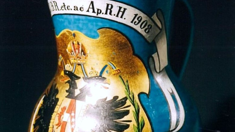 A decorated jug with imperial coat of arms and inscription from 1908.