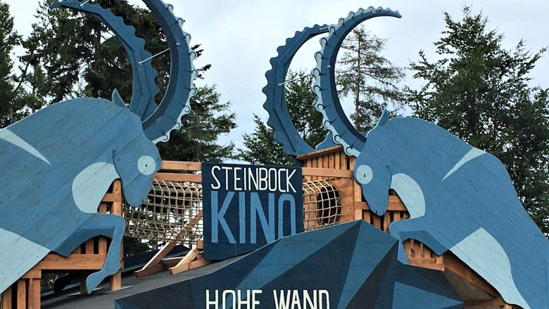 Wooden sculptures of ibexes with the inscription 'Steinbock Kino Hohe Wand'.