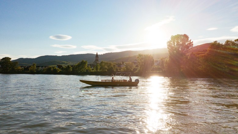 Boat on a river at sunset in the Wachau.