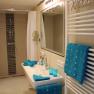 Modern bathroom with shower, washbasin and blue towels.
