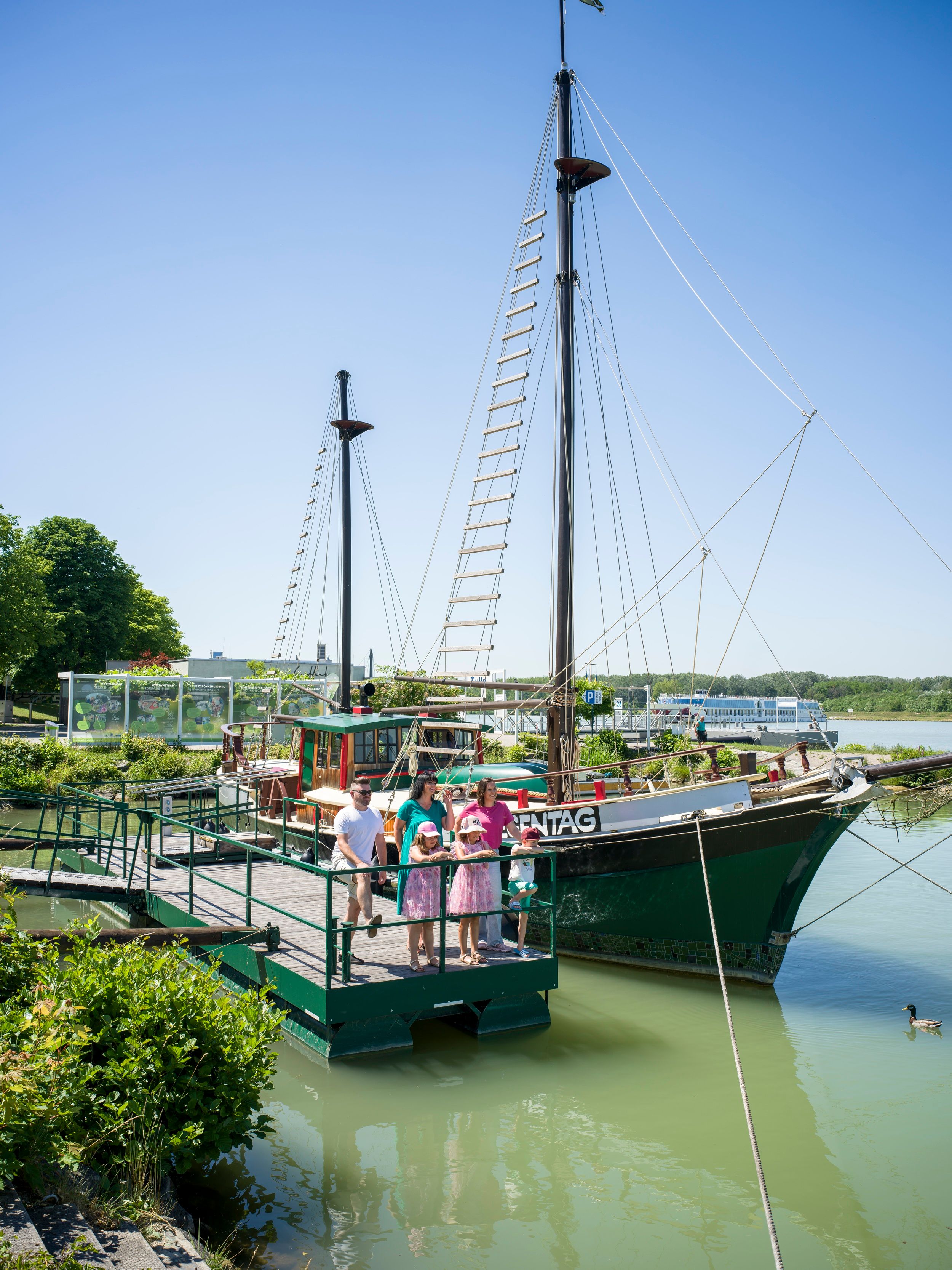 historic ship with a family standing in front of it 