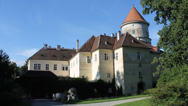Castle in Pyhra with tower and garden in sunny weather.