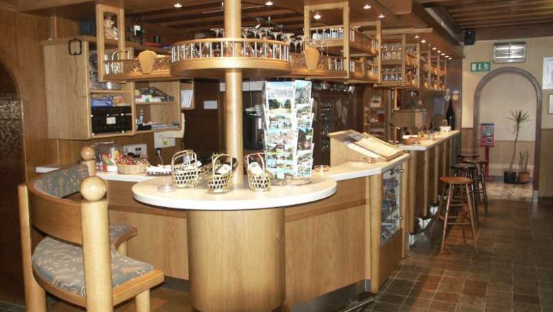 Interior view of a cozy bar with wooden furniture and counter.