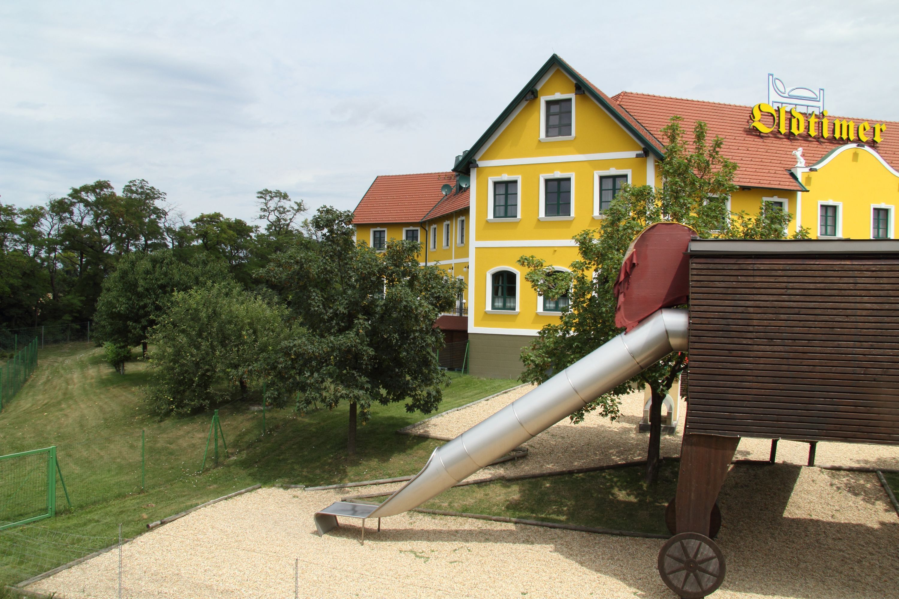 Yellow building with red roof and slide in the foreground.