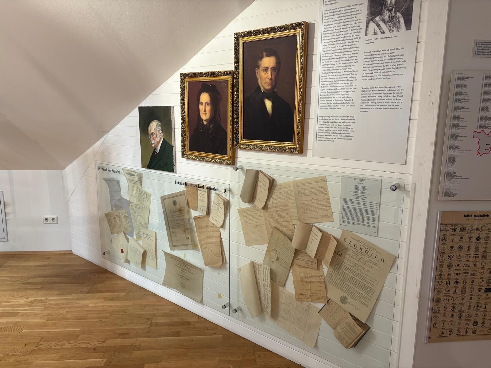 Exhibition in the Sugar Museum with portraits and historical documents on the wall.