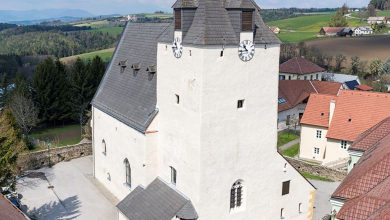 Lichtenegg fortified church with massive clock tower and surrounding buildings.