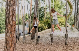 Children playing on an outdoor climbing course.