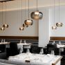 Modern restaurant with elegant hanging lamps and laid tables.