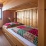 Wood-paneled room with bunk beds and checkered ceilings.
