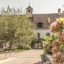 Inner courtyard of the Holzapfel winery with flowering plants and an old building in the background.