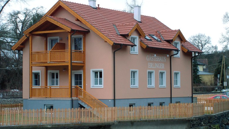 Guesthouse Erlinger, © Gästehaus Erlinger Erlinger guest house with wooden veranda and fence.