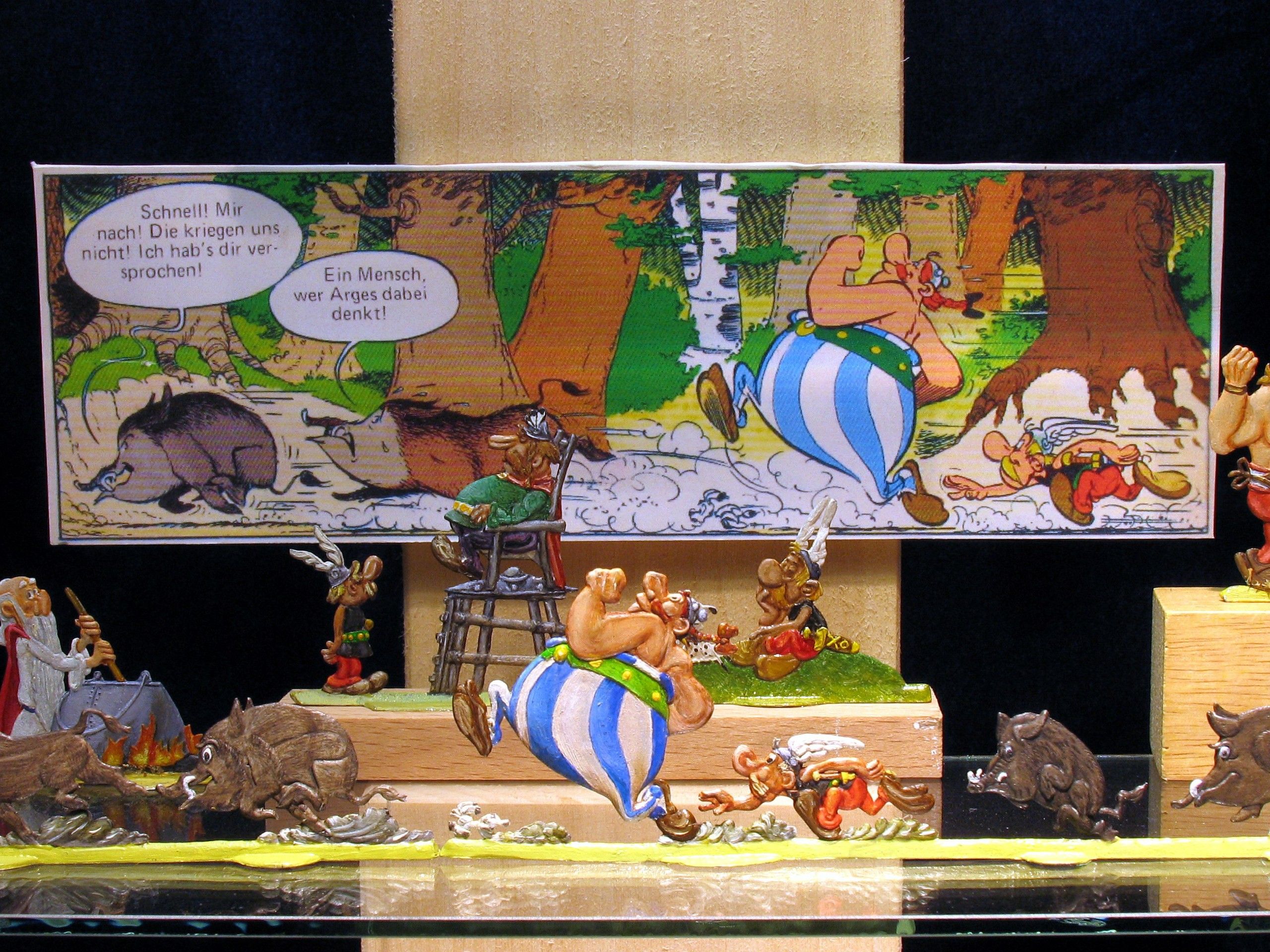 Pewter figures of comic characters in front of a comic background.