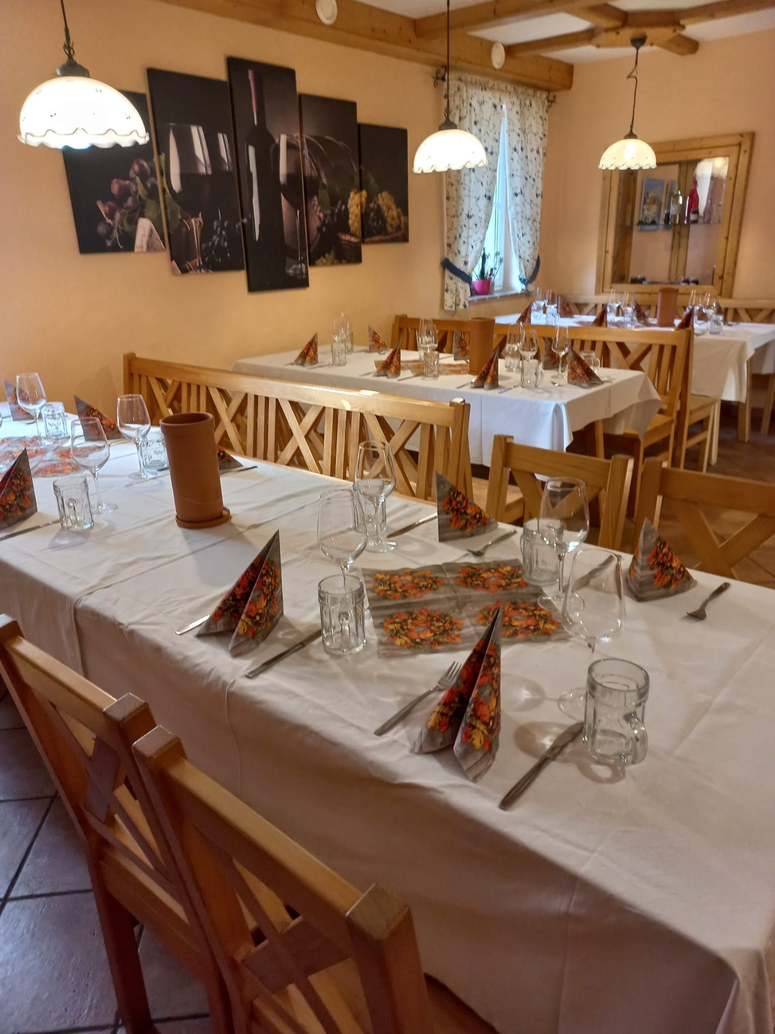 Tables set inside with white tablecloth and napkins 