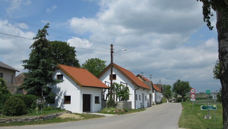 Wine cellar lane in Gro&szlig;kadolz with white houses and red roofs along a street.