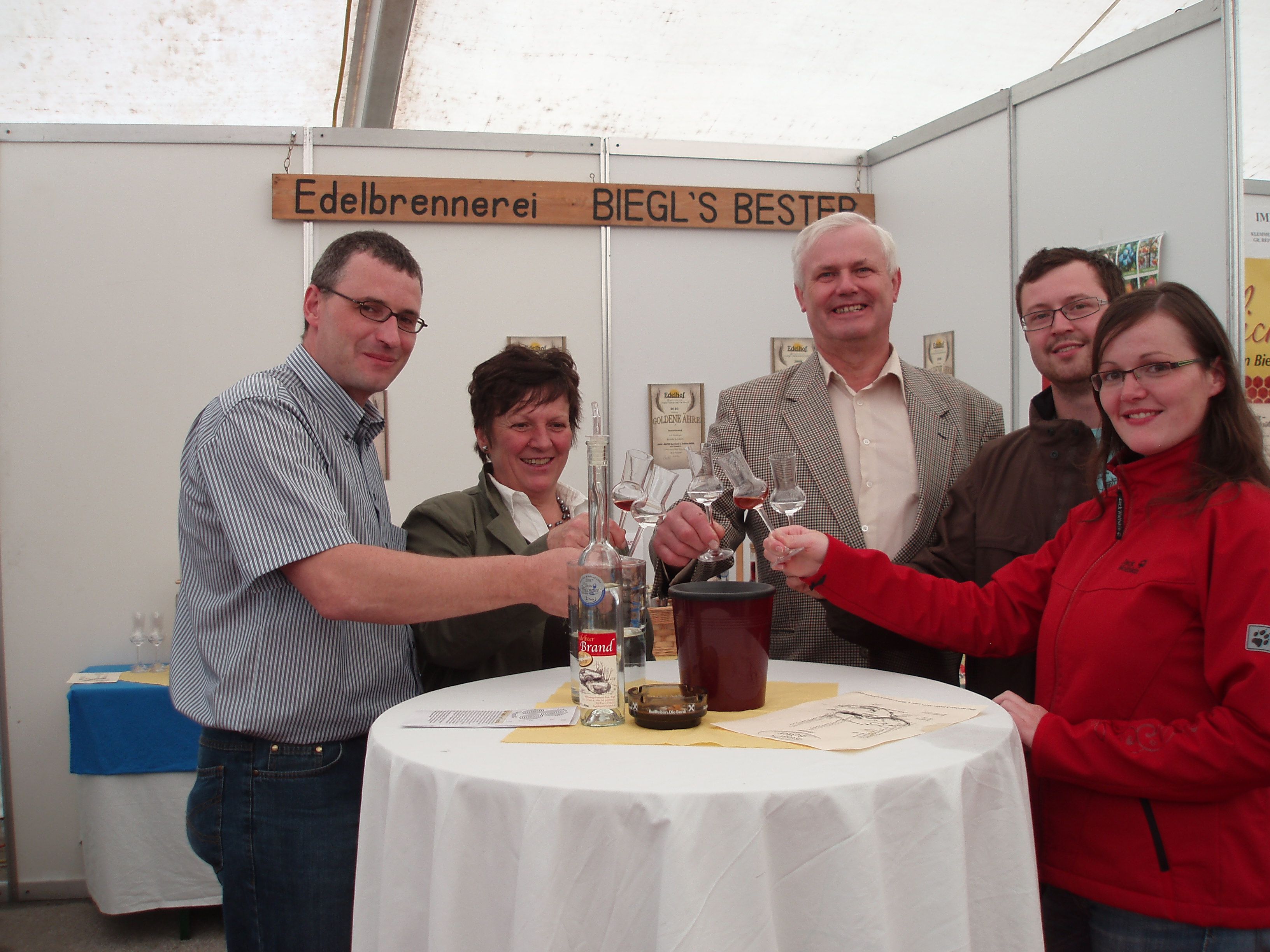 Group of five people clinking glasses at a table.