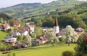 Rural landscape with church and blossoming trees.