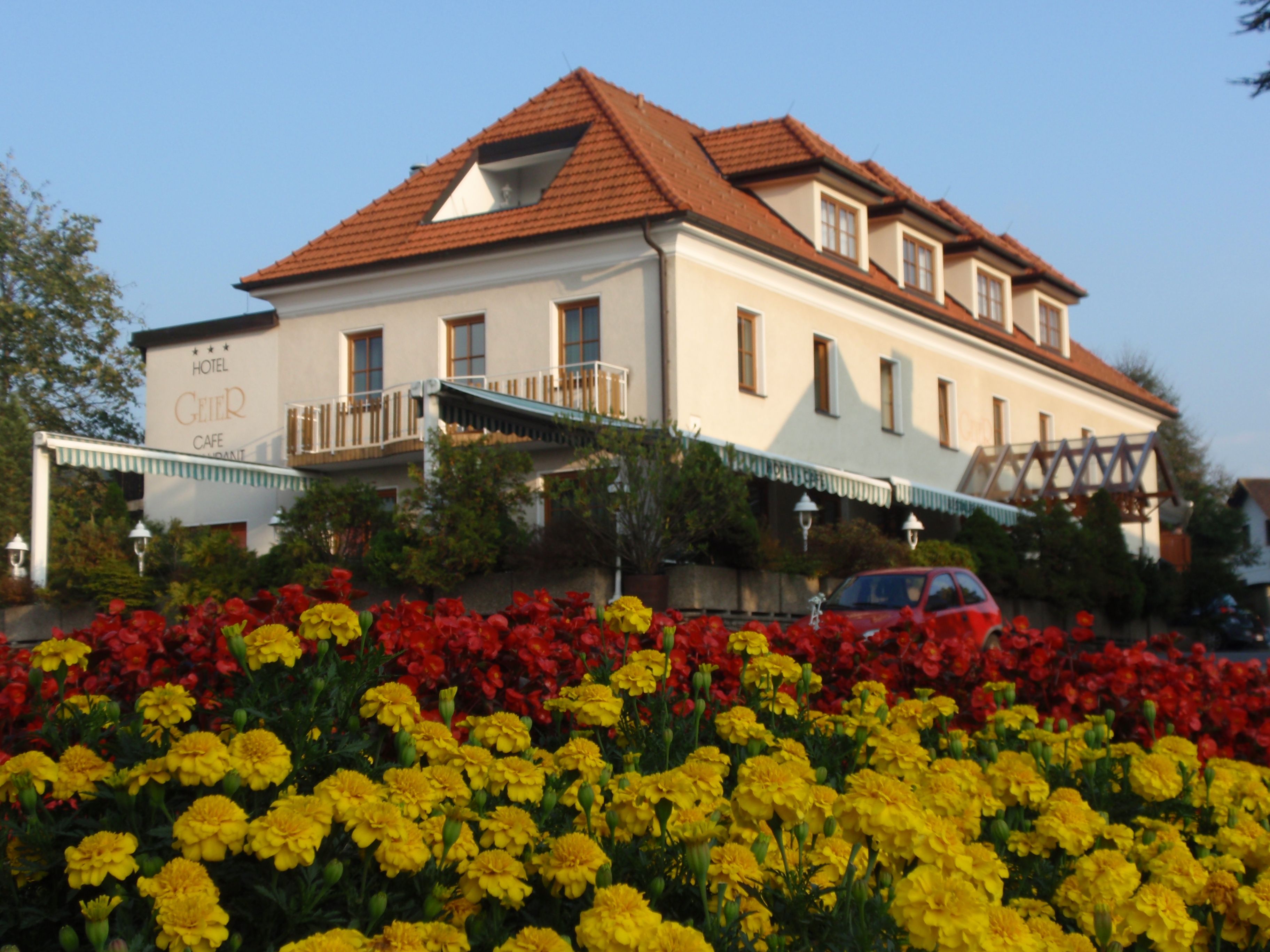 Hotel Geier in Bad Schönau with flower bed in the foreground.