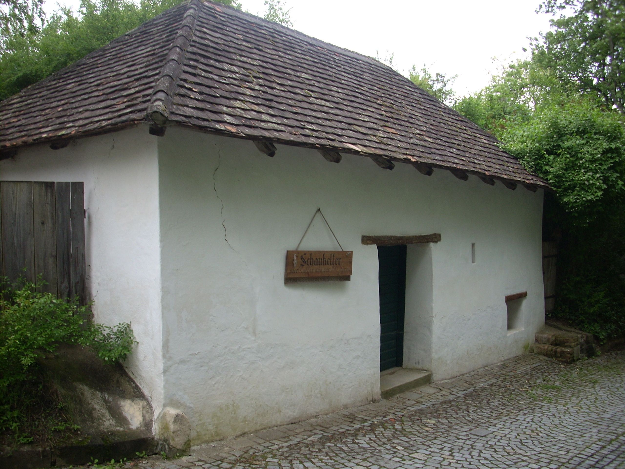 A traditional building with a white façade and tiled roof, labeled 'Schaukeller'.