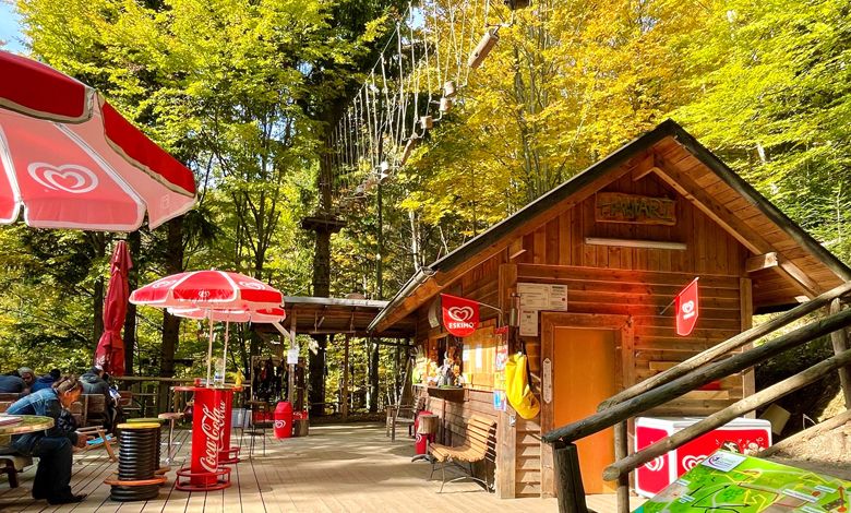 Wooden hut with sunshades and climbing park in the background.