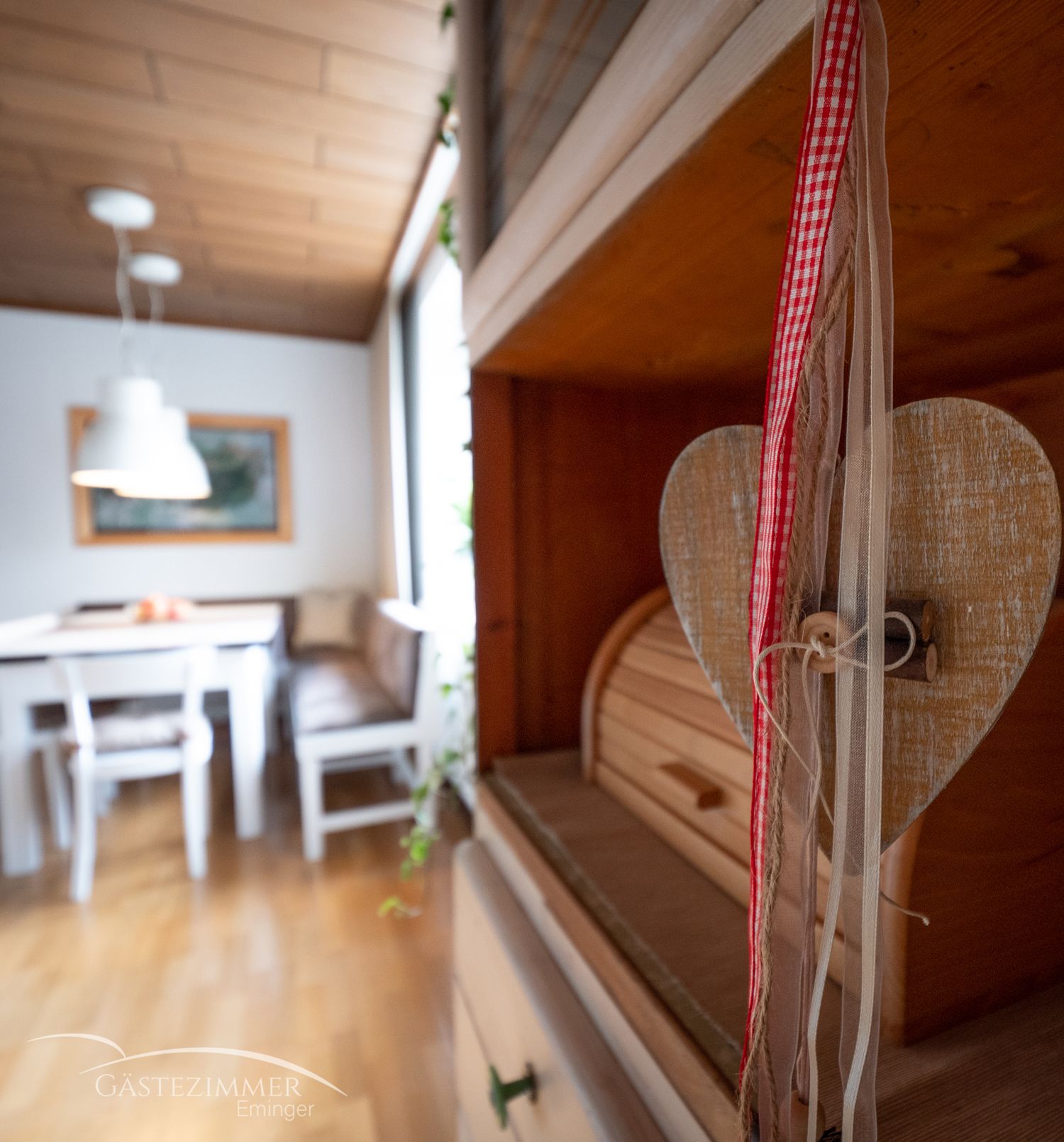 Cozy eat-in kitchen with wooden furniture and heart decoration.