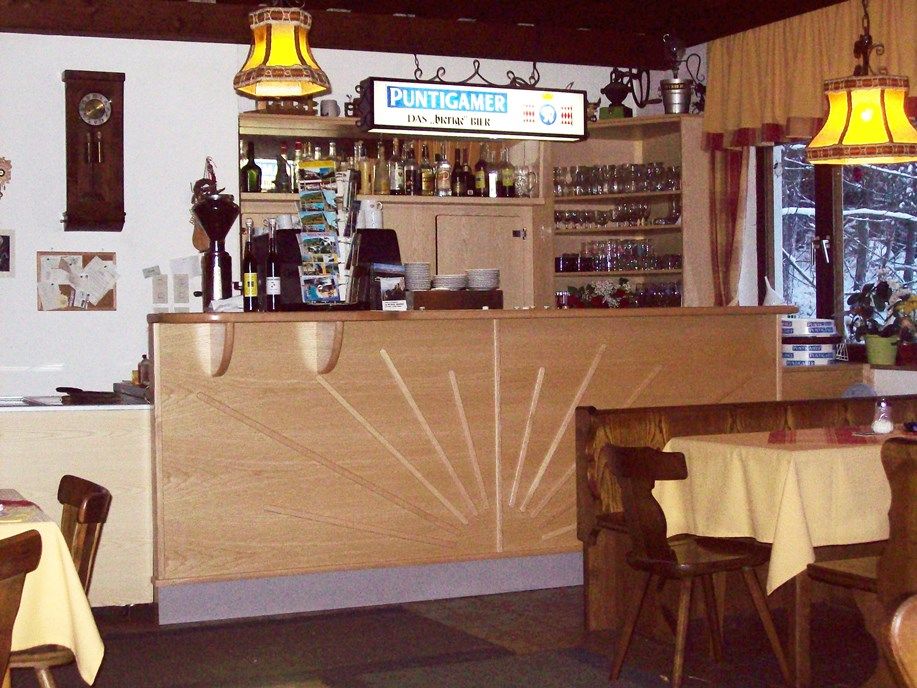 Interior view of an inn with bar and tables.