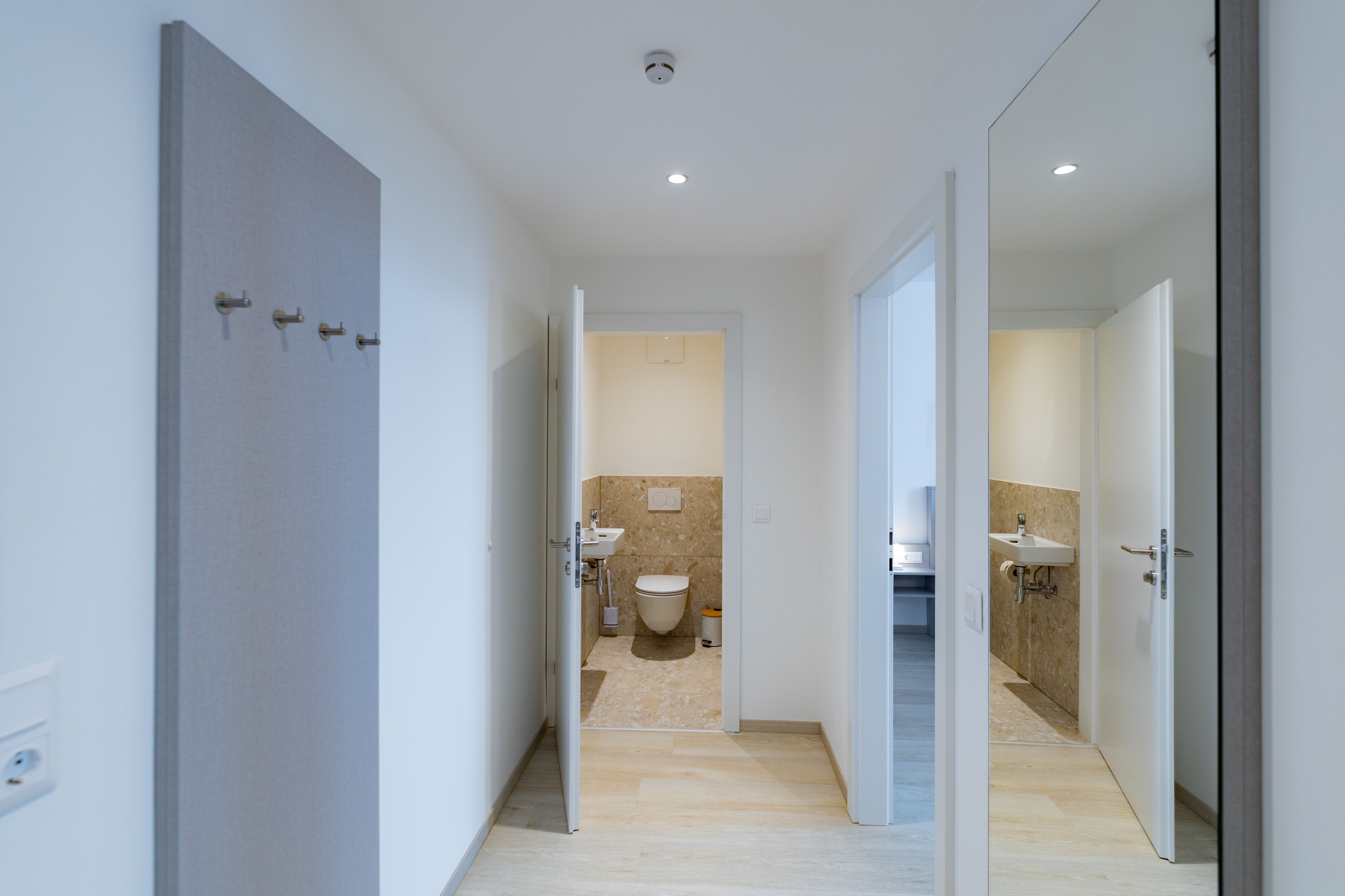 Hallway with a view of the bathroom and mirror on the wall.