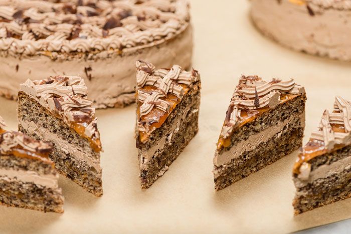 Close-up of sliced chocolate cake pieces with cream and chocolate icing.