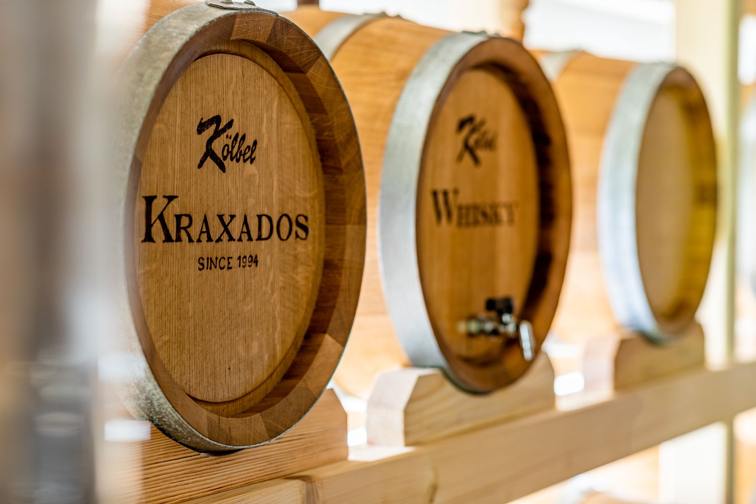 Large wooden barrels labeled "Kraxados" and "Whiskey" in a storage room.