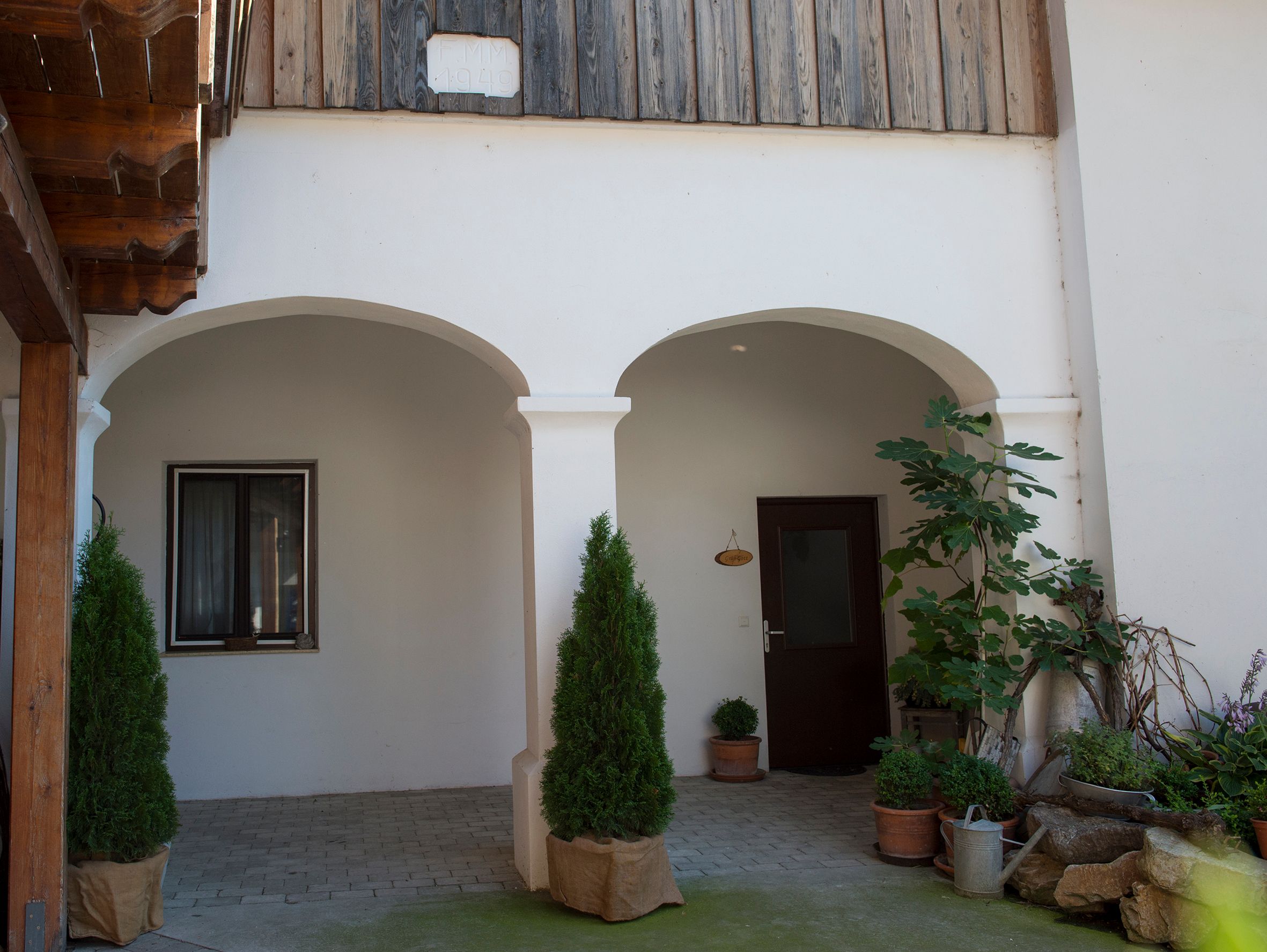Inner courtyard of the complex with plants and two brick arches.