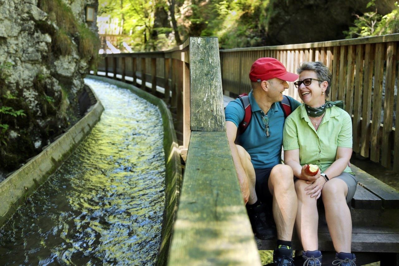 A couple takes a break on the steps of the footbridge, right next to the Trift Canal.