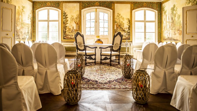 State Hall in Schloss Luberegg with decorated chairs, carpet and wall paintings.