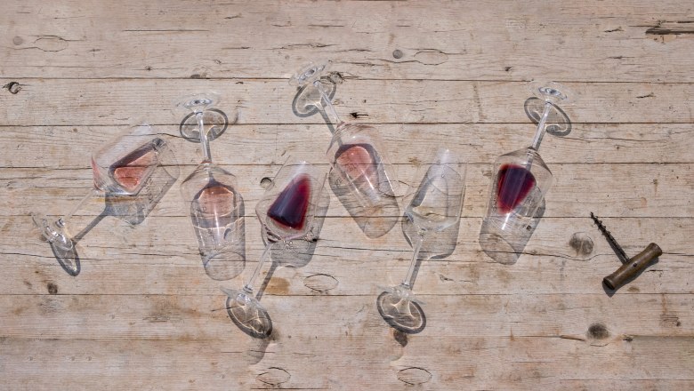 Wine glasses with red wine lying on a wooden table.