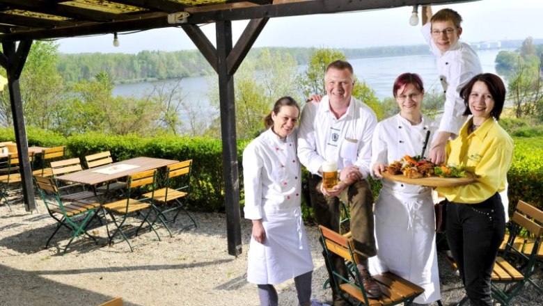 A team of five people in a beer garden overlooking a river.