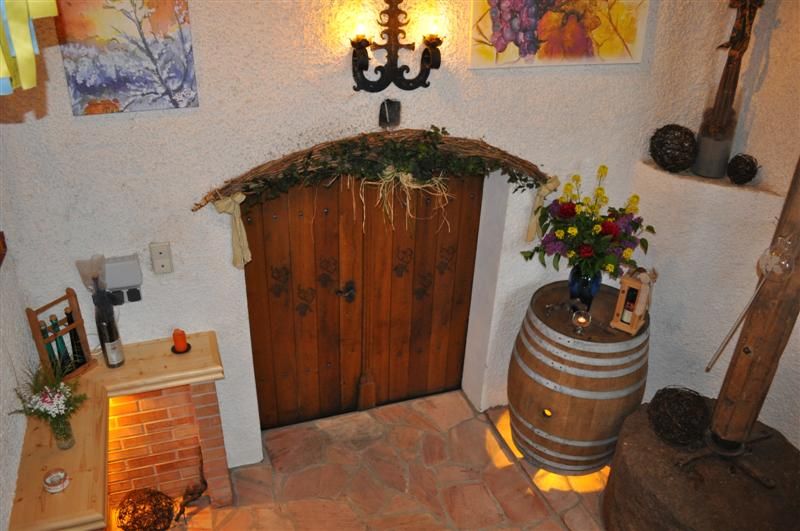 Rustic wine cellar decoration with wooden door, flowers and wine barrel.