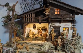 Detailed nativity scene with figures and animals in a rustic stable.