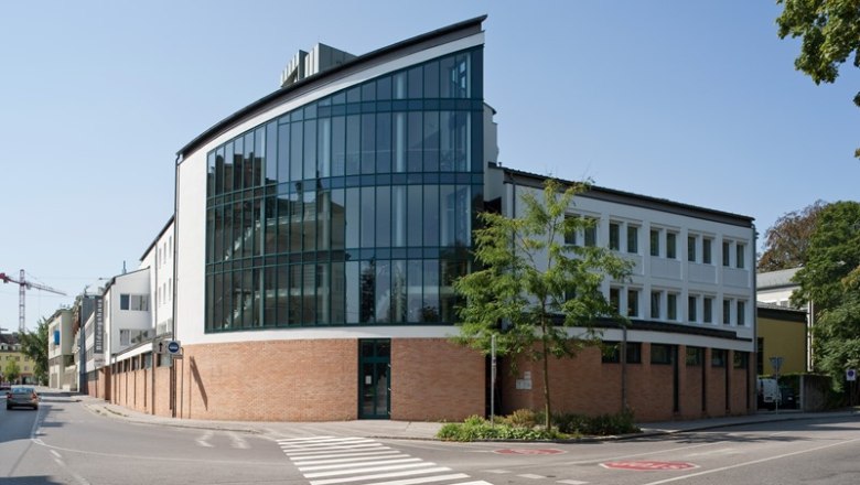 St. Hippolyt House of Education, © Werner Jäger Modern building with glass façade and brickwork on a street corner.