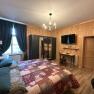 Comfortable hotel room with wooden walls, double bed, desk, closet and flat-screen TV.