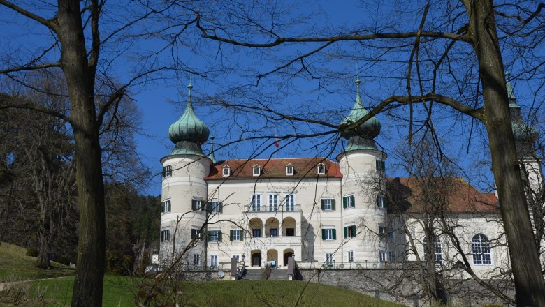 Artstetten Castle with two striking towers and blue sky in the background.