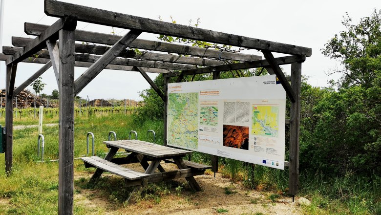 Cyclists' rest area with wooden table and information board on the Wine Road in the Weinviertel.