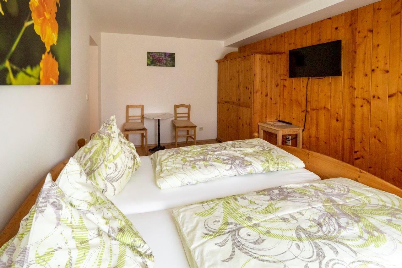 Comfortable guest room with double bed, wooden furniture and TV.