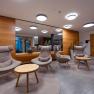 Modern hotel lobby with comfortable armchairs and wooden tables.