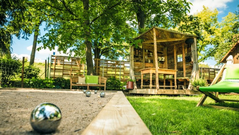 Garden with pergola and sand area with boccia ball, sun lounger next to it